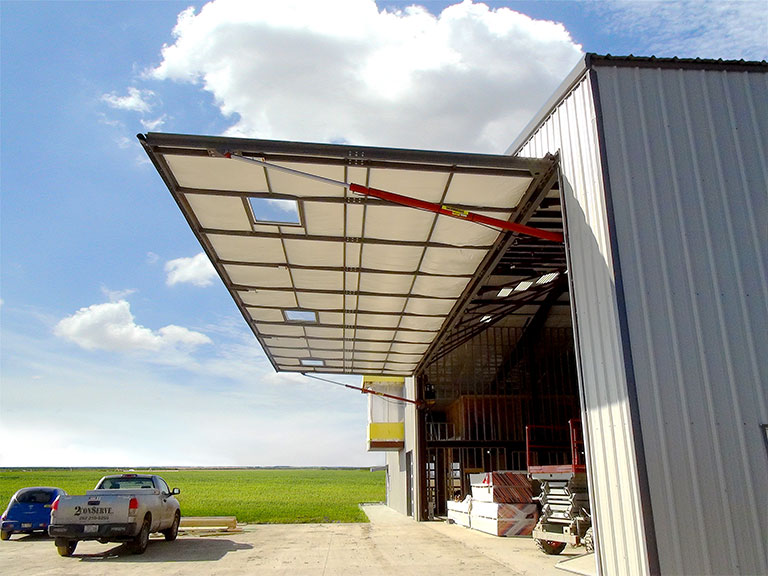 Hydraulic door with red power pumps on equipment shed